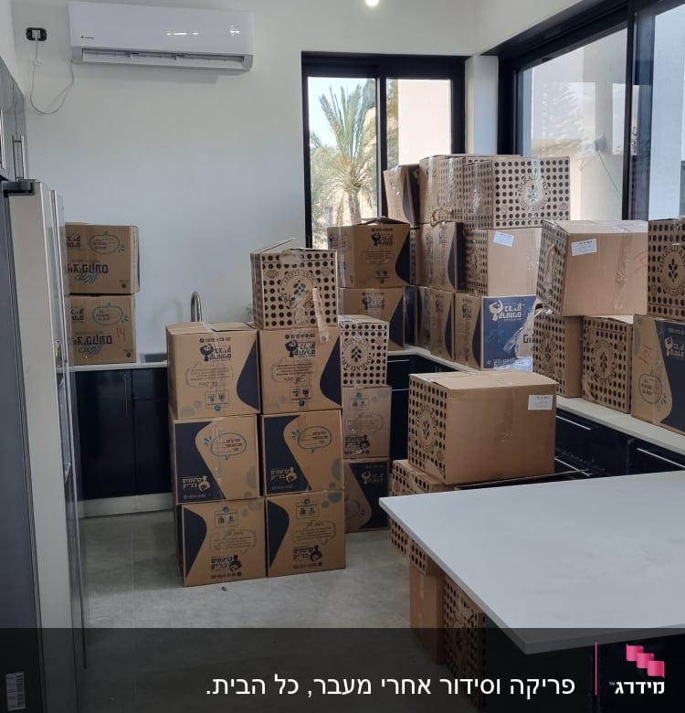 ארגזים מסודרים בחדר עם חלונות גדולים ומזגן